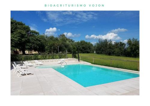 a swimming pool with two chairs at Bio Agriturismo Vojon in Ponti Sul Mincio