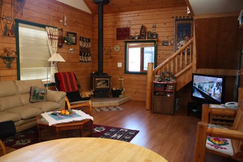 a living room with a couch and a stove at The Gingerbread Cabin in Jasper