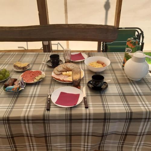 un tavolo con una tovaglia a quadri con del cibo sopra di viesu nams "Laimes pakavs" a Straupe
