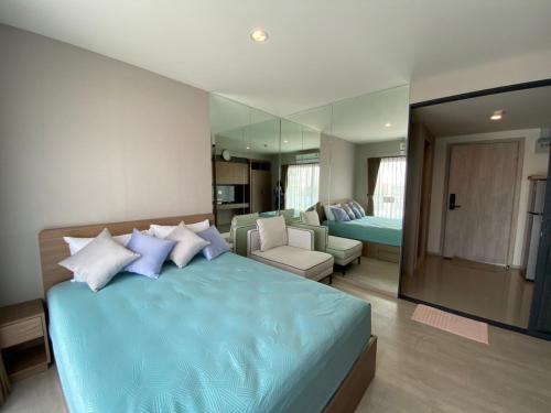 a bedroom with a blue bed and a living room at Luxury La casita Huahin in Hua Hin