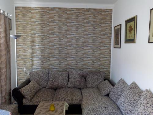 a living room with a couch and a brick wall at Vodice Mladen apartman za familiju in Vodice