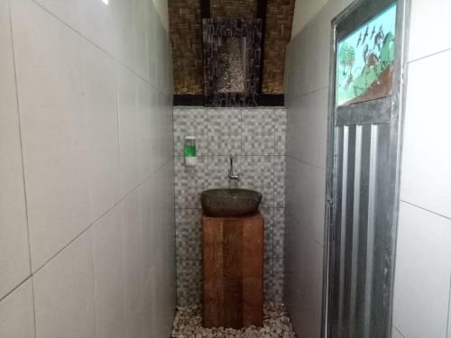 a small bathroom with a sink in a room at Zelobi Omnivora Cottage in Kintamani