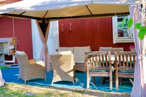 a table and chairs under a white umbrella at Blommenshage in Grisslehamn