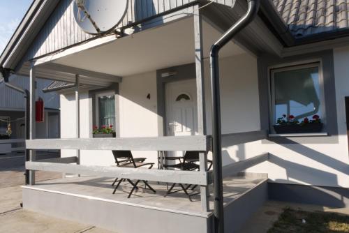 a house with two chairs on the front porch at Gabriella Panzió in Bük