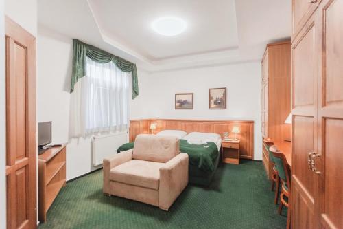 une chambre d'hôtel avec un lit et une chaise dans l'établissement Hotel Peko, à Prague