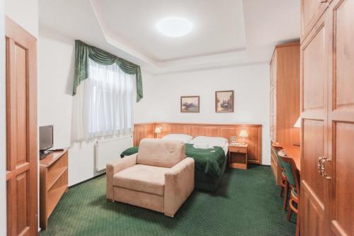 プラハにあるホテル ペコのベッドと椅子付きのホテルルーム