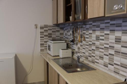 a kitchen counter with a sink and a microwave at Gabriella Panzió in Bük