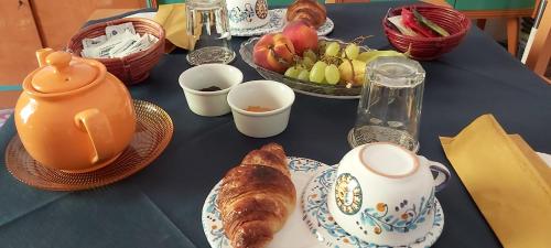 a blue table with a breakfast of croissants and fruit at B&B SoleLuna della Solidarietà in Palermo