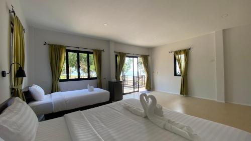 a large bedroom with two beds and a living room at Cozy Khanom โคซี่ ขนอม in Ban Na Dan