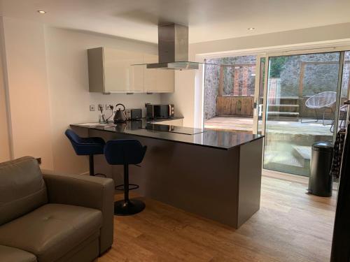 a kitchen with a counter and a living room at Mitre Court Holiday Home in Plymouth