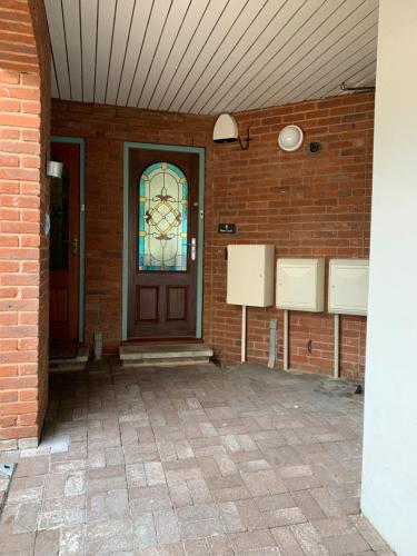 Mitre Court Holiday Home في بلايموث: جدار من الطوب مع باب ونافذة زجاجية ملطخة