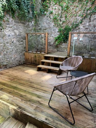 twee stoelen en een bank op een houten terras bij Mitre Court Holiday Home in Plymouth