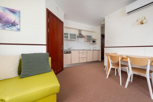 een woonkamer met een gele bank en een tafel bij Villa Baltic -Apartament nr 9 in Chałupy