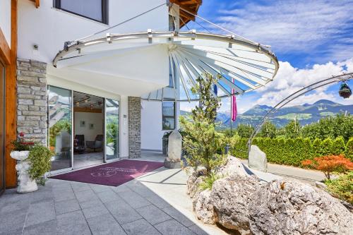 a home with a patio with an umbrella at Mineralienhotel Natznerhof in Natz-Schabs