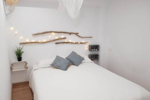 una camera da letto con un letto bianco e luci di Amb encant i estil Mediterrani en zona tranquilla de Llançà i amb terrassa a Llança