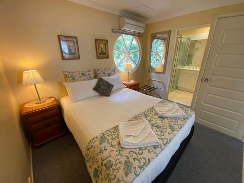 a bedroom with a bed with two towels on it at Curtis Cottage in Mount Tamborine