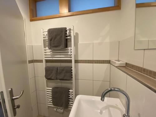 a bathroom with a sink and a towel rack at Apartments Rischmühle in Emmerthal
