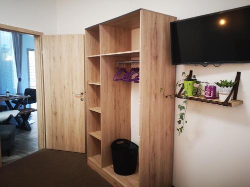 a wooden book shelf with a flat screen tv on a wall at APARTMENT WALD - im Skigebiet Gerlitzen & Ossiacher See in Bodensdorf