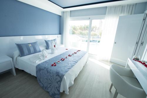 a bed room with a white bedspread and white pillows at Masd Mediterraneo Hotel Apartamentos Spa in Castelldefels
