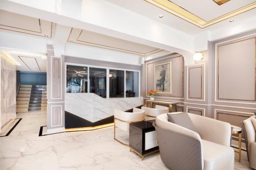 a living room with a bed and chairs at Penyos Suite in Bangkok