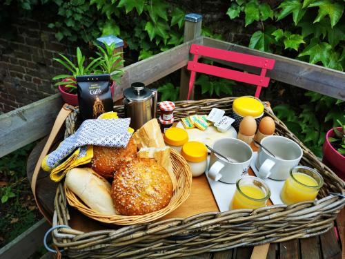 een mand met brood en eieren op een tafel bij La Maison des Oiseaux. Roulotte in Achicourt