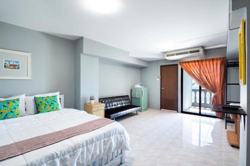 a bedroom with a bed and a couch and a television at Penyos Suite in Bangkok