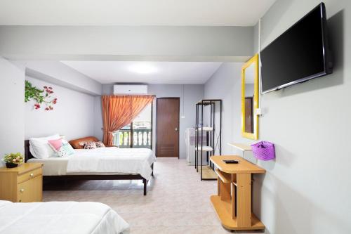 a hotel room with two beds and a flat screen tv at Penyos Suite in Bangkok