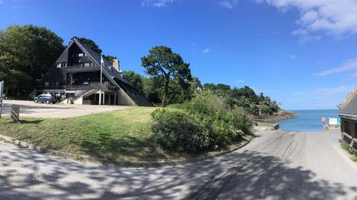 a house on a hill next to the ocean at Auberge de Jeunesse HI Cancale in Cancale