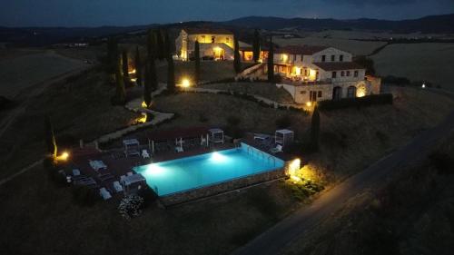 an aerial view of a house with a swimming pool at night at Agrihotel Il Palagetto in Volterra
