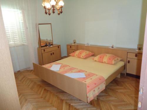 a bedroom with a large bed and a mirror at APARTMAN ZORAN MARUSIC in Marusici 