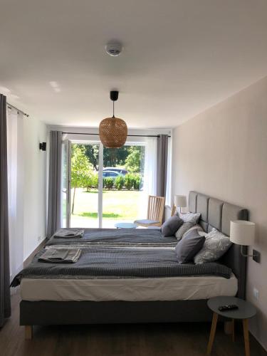 een slaapkamer met een groot bed met een groot raam bij Willa Mała Czarna in Wisła