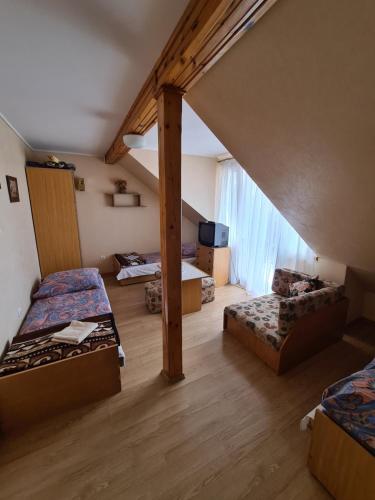 a attic room with two beds and a couch at Ośrodek wczasowy Ewa in Łeba