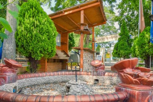 a fountain in a garden with red chairs and a bench at Boutique Hotel Sena in Berlin