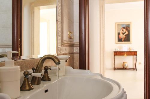 a bathroom with a sink and a mirror at La Maison in Grottaglie