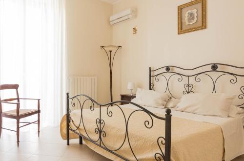 a bedroom with a bed and a chair in a room at La Maison in Grottaglie
