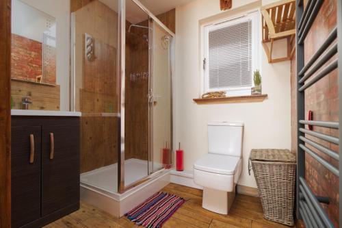 a bathroom with a shower and a toilet and a sink at Braeside Cabin in Clackmannan