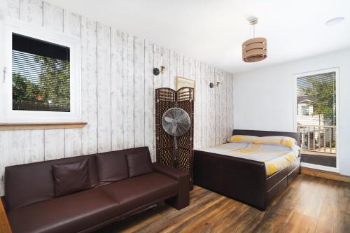 um quarto com uma cama, um sofá e um relógio em Braeside Cabin em Clackmannan