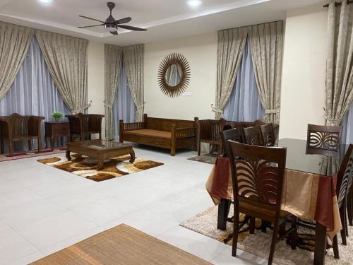 uma sala de estar com mesa e cadeiras em Ilham Bonda Homestay em Cukai