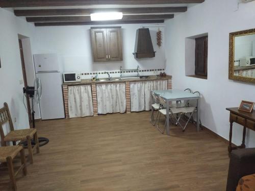 a room with a kitchen with a table and a refrigerator at La Casa del Abuelo Jose in Marmolejo