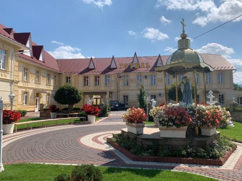 un edificio con una estatua en medio de un patio en Staryj Kosiv, en Staryi Kosiv