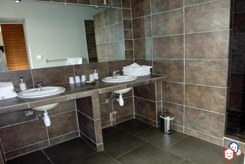 La salle de bains est pourvue de 2 lavabos et d'un grand miroir. dans l'établissement Hôtel de Valdeblore, à Valdeblore