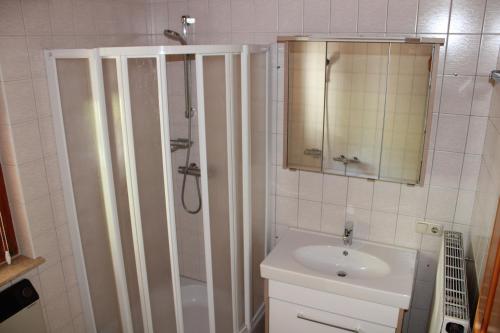 een witte badkamer met douche en wastafel bij Ferienwohnung in der Schoß in Schruns