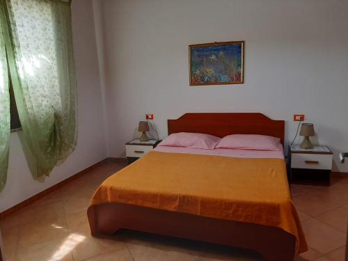 um quarto com uma cama grande e 2 mesas de cabeceira em Vacanze da Macandu & Stefi em San Giovanni Suergiu