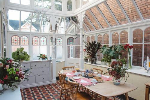 a dining room with a table in a conservatory at Ashburton Court in Ashburton
