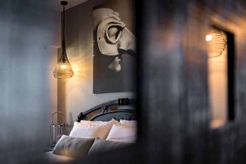 a bedroom with a bed with a picture on the wall at Anthemion Suites and Villas in Nafplio