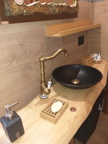 a bathroom with a black sink on a wooden counter at La Corte di Nonno Gino in Stresa