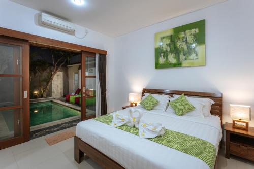 a bedroom with a bed and a swimming pool at Villa Sedana in Seminyak