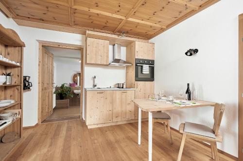 a kitchen with wooden cabinets and a wooden table at Marbergerhaus Umhausen in Umhausen