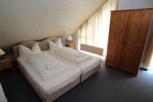 ニーダーンハウゼンにあるHotel Garni Am Schäfersbergのベッドルーム1室(大型ベッド1台、白いシーツ、枕付)