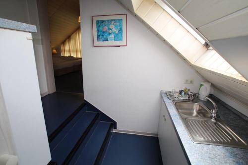 a bathroom with a sink in a room with a bed at Hotel Garni Am Schäfersberg in Niedernhausen